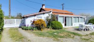 a small white house with a table and chairs at Maison ZEN climatisée in Commequiers