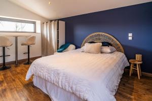 una camera da letto con un letto grande con una parete blu di Le gite de la Bille a Coubon