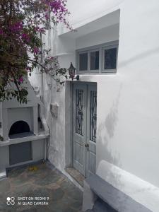 un edificio bianco con una porta e una finestra di Θέτιδα House a Skiros