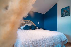 una camera da letto con un letto con pareti blu di Le gite de la Bille a Coubon Altre 3 foto