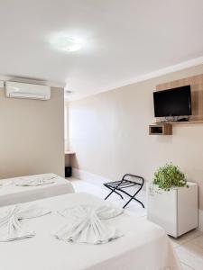 a room with two beds and a tv on the wall at Palace Hotel in Cristalina +9 photos