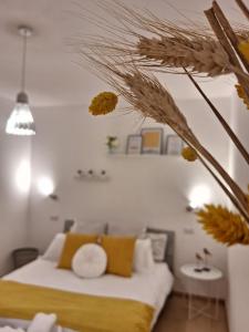 a bedroom with a bed with yellow and white pillows at Elunà Assisi Home in Assisi
