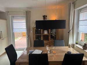 a dining room with a wooden table and chairs at Haus Rehkitz RE07 in Sögel