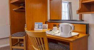 a wooden desk with a tea kettle on it at Best Western Corona Hotel in London