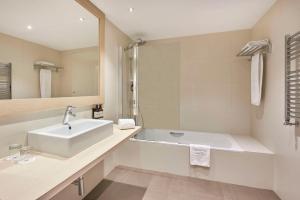a bathroom with a sink and a bath tub at NH Barcelona Stadium in Barcelona
