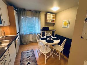 a small kitchen with a table and chairs in a room at Mysig legenget nära Isaberg in Nissafors