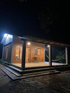 una pequeña casa con porche por la noche en Cabaña El Refugio del Jochi, en Buena Vista 3 fotos más