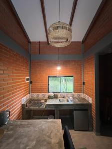 cocina con fregadero y pared de ladrillo en Cabaña El Refugio del Jochi, en Buena Vista