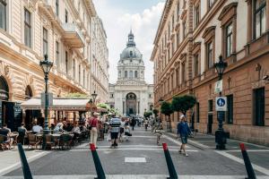 Una calle con gente caminando por una calle con un edificio. en W33 - Prime Location - Comfortable Quality Apartments by BQA, en Budapest