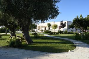 una pasarela frente a un edificio con un árbol en Willaria Country House, en Cursi