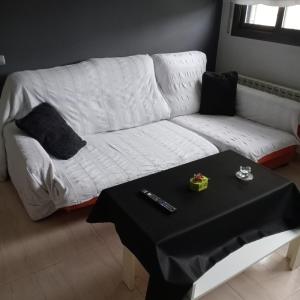 a white couch in a living room with a table at Apartamento Castellet1 in San Vicente de Castellet