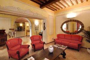 a living room filled with couches and chairs at Hotel Bologna in Pisa