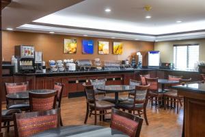 a restaurant with tables and chairs and a bar at Comfort Inn & Suites Hutchinson in Hutchinson