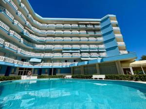hotel z basenem przed budynkiem w obiekcie Fresh and cozy seaside studio w mieście Porto Santa Margherita di Caorle