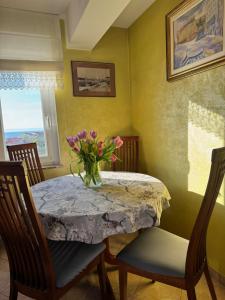 a dining room table with a vase of flowers on it at apartment IVA in Supetarska Draga