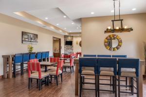een restaurant met tafels en stoelen en een spiegel bij Comfort Inn & Suites Augusta in Augusta