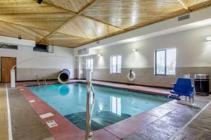 a swimming pool with a blue chair in a building at Comfort Inn & Suites Shawnee - Kansas City in Shawnee