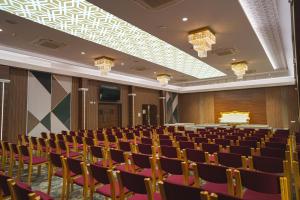 a lecture hall with chairs and a cake on the ceiling at Highland Hotel in Bengaluru