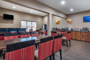 a dining room with a table and red chairs at Comfort Inn & Suites Junction City - near Fort Riley in Junction City