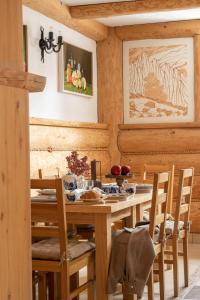 a dining room with a wooden table and chairs at Willa Podhalanka Jacuzzi & sauna - drewniany dom dla 20 osób in Biały Dunajec