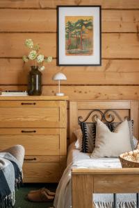 a bedroom with a bed with a wooden wall at Willa Podhalanka Jacuzzi & sauna - drewniany dom dla 20 osób in Biały Dunajec