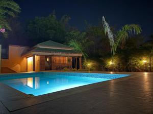 a swimming pool in front of a house at night at Olive Resort - Sillari Pench in Silāri