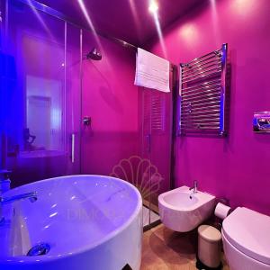 a pink bathroom with a tub and a sink at Villa Emiele in Mola di Bari +63 photos