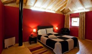 a red bedroom with a bed and a red wall at House 1 in Fafe