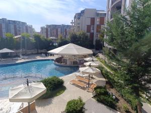 an outdoor swimming pool with umbrellas and chairs and a pool at Rainbow 3-213 Large Studio Delux in Sunny Beach