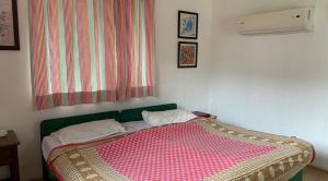 a bedroom with a bed with a colorful blanket on it at Camp Temgarh in Lavasa
