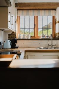 eine Küche mit Spüle und Fenster in der Unterkunft Sweetheart Cottage - Cosy 2 Bed in The Cotswolds! in Swalcliffe + 98 Fotos