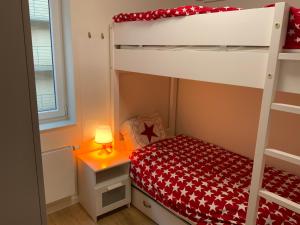 a bedroom with a bunk bed with a red bedspread at La madeleine in De Panne