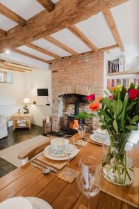 ein Wohnzimmer mit einem Holztisch und einem Kamin in der Unterkunft Sweetheart Cottage - Cosy 2 Bed in The Cotswolds! in Swalcliffe