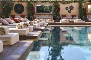 a hotel pool with lounge chairs and a swimming pool at The Margi in Athens