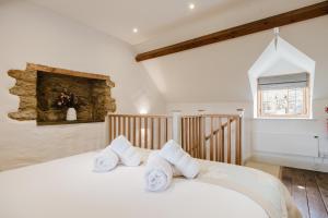 ein Schlafzimmer mit einem weißen Bett mit Handtüchern darauf in der Unterkunft Sweetheart Cottage - Cosy 2 Bed in The Cotswolds! in Swalcliffe