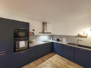 a kitchen with blue cabinets and a sink at B&B HOTEL Rodez Bourran in Rodez +31 photos
