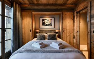 Un dormitorio con una cama grande con dos toallas. en Les Chalets D'Anthouard, en Crest-Voland