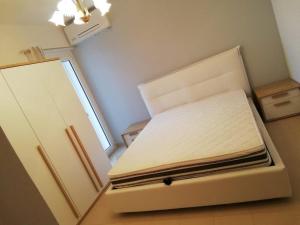 Stazione di San SosteneにあるCasa primo piano a due passi dal mareの冷蔵庫付きの客室の白いベッド1台分です。