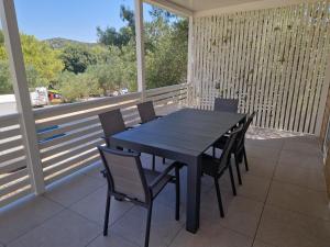 a black table and chairs on a screened in porch at Mobile homes Jezera Lovišća Premium in Jezera +20 photos