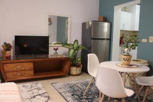a living room with a tv and a table with chairs at Herrmes in Sharm El Sheikh