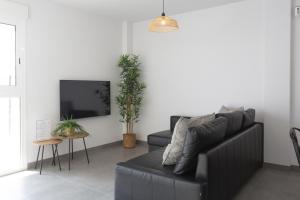 Una sala de estar con un sofá y un televisor. en AT Gregal I, en La Playa de la Torre de Piles 11 fotos más