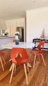 a kitchen with a table and two chairs and a vase with flowers at Cozy Room with Private Bathroom in Wheelers Hill