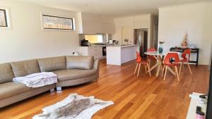 a living room with a couch and a table with chairs at Cozy Room with Private Bathroom in Wheelers Hill