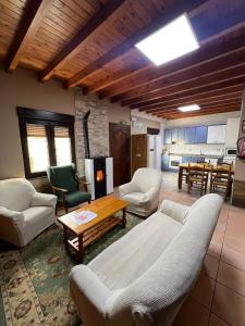 ein Wohnzimmer mit Sofa, Stühlen und einem Tisch in der Unterkunft Gestiona2R - Casa para 5 personas con terreno en La Franca in Las Conchas