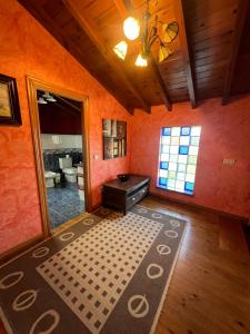 ein Wohnzimmer mit orangefarbenen Wänden, einem Tisch und einem Fenster in der Unterkunft Gestiona2R - Casa para 5 personas con terreno en La Franca in Las Conchas + 24 Fotos