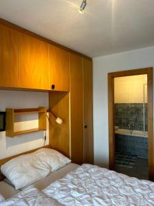a bedroom with a bed and a bathroom with a tub at Melezes K 021 - SKI & NATURE apartment 6 pers in Veysonnaz