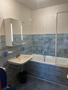 a blue tiled bathroom with a sink and a tub at Melezes K 021 - SKI & NATURE apartment 6 pers in Veysonnaz +3 photos