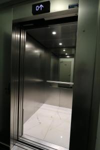 an elevator in a building with a mirror at Hôtel Napoléon in La Turbie