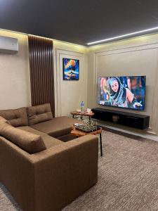 a living room with a couch and a flat screen tv at Top Notch- 2 BHK Condo Travel Pin in Lahore