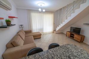 ein Wohnzimmer mit Sofa und Fernseher in der Unterkunft Sunset Beach Club Aqualettings Poseidon 7 in Fethiye